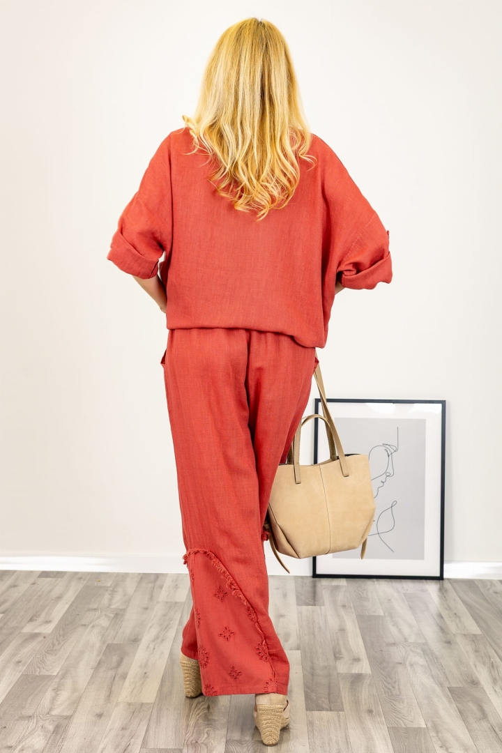 Wygodne spodnie z lnu w kolorze róż indyjski z ozdobnymi strzępieniami i kwiatkami.