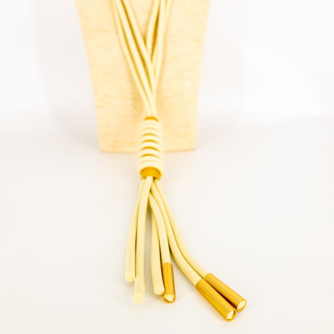 Długi naszyjnik Orsomarsoa w kolorze jasnobeżowym – lekki, miękki, z dekoracyjną rurką i frędzlami.