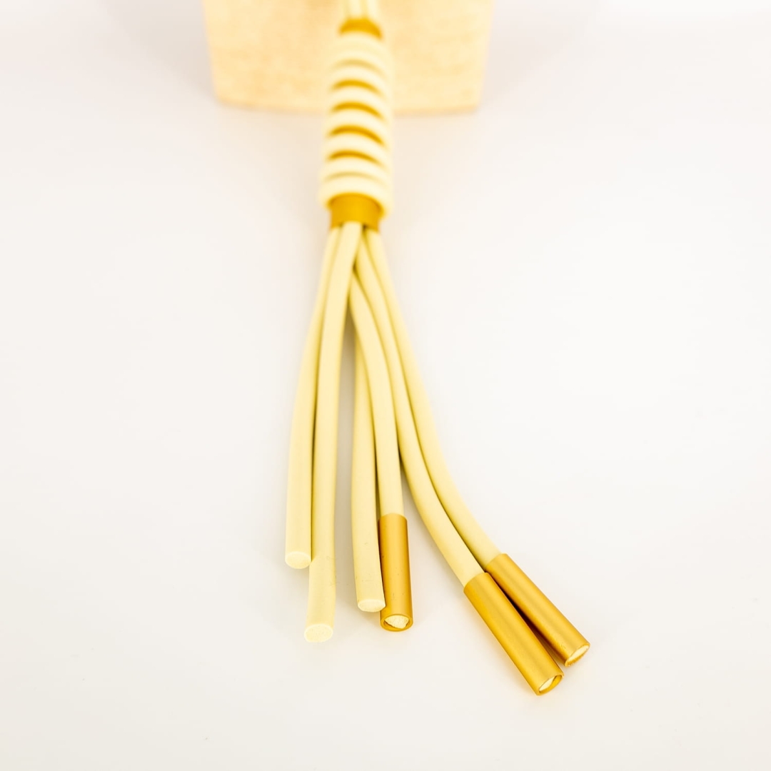 Stylowy jasnobeżowy naszyjnik Orsomarsoa – wykonany z silikonowych sznurków, z ozdobnym zakończeniem.