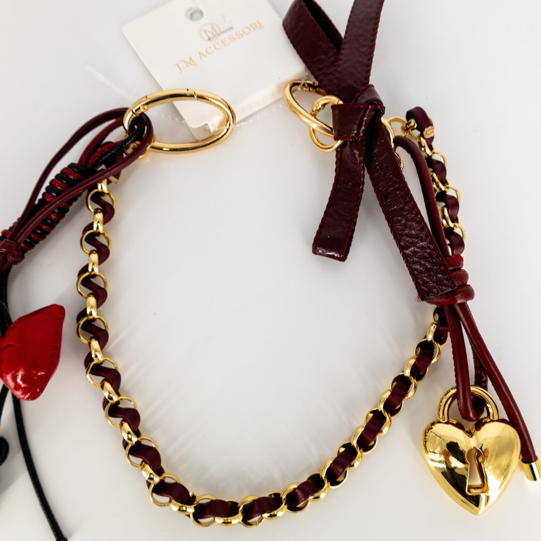 Bordowa przypinka statement z dekoracyjnym łańcuszkiem.