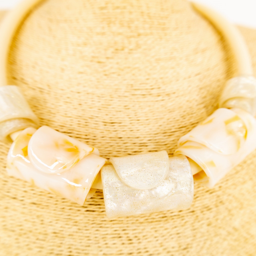 Regulowany naszyjnik w jasnej kolorystyce.