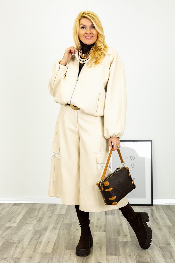 Kuloty Landiona w kolorze beżowym o nowoczesnym kroju z szerokimi nogawkami długości 7/8 gumką w pasie kieszeniami z przodu i z tyłu oraz koronkowym detalem Antaresa