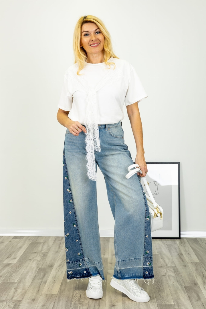 Spodnie jeansowe z szeroką nogawką kieszeniami z przodu i z tyłu aplikacjami w stokrotki boczną wstawką i strzępionym dołem Rapolla