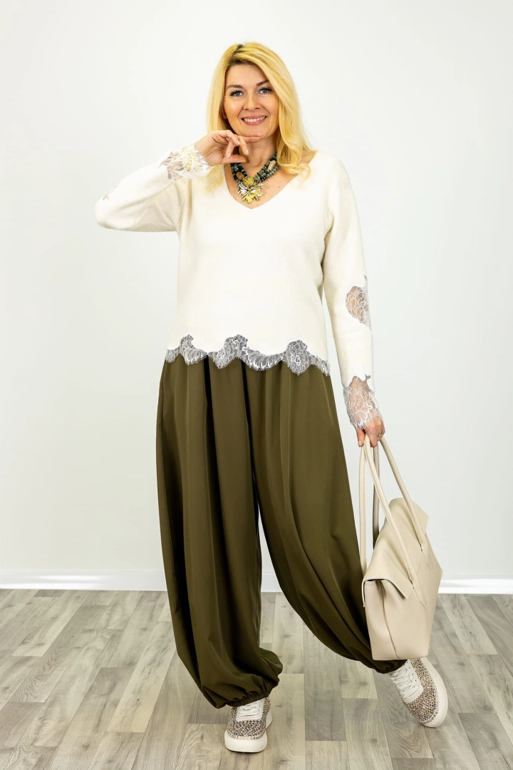 Sweter prezentowany na modelce zachwyca ozdobnymi koronkami