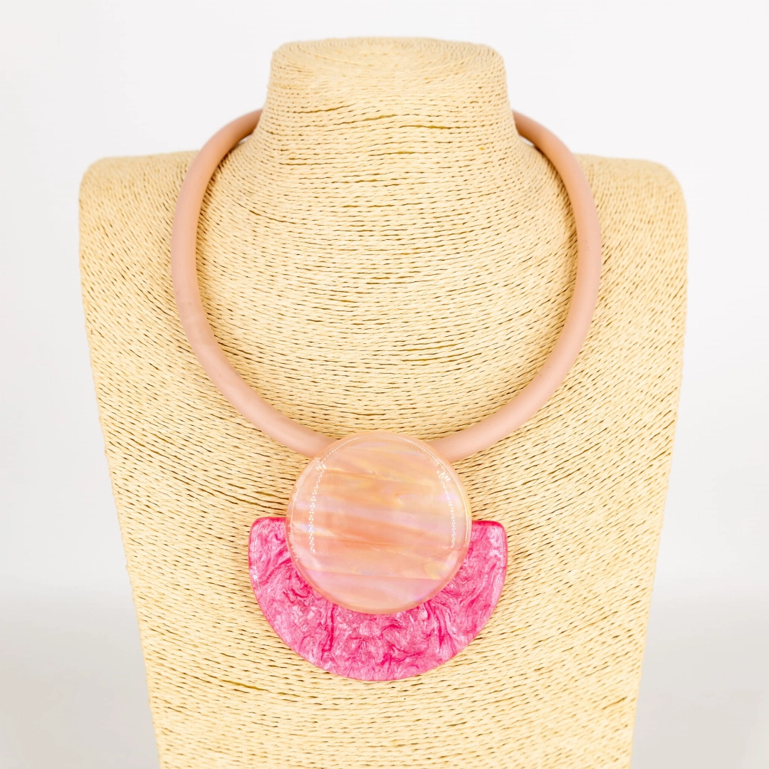 Różowy naszyjnik z marmurkowym wisiorkiem w kształcie koła.