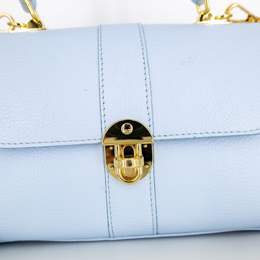 Błękitna skórzana torebka kuferek z krótką rączką i długim paskiem na ramię