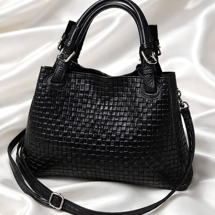 Czarna skórzana torebka pleciona typu shopper z regulowanymi brązowymi uszami.