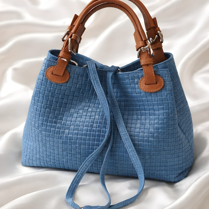 Niebieska skórzana torebka pleciona typu shopper z regulowanymi brązowymi uszami.
