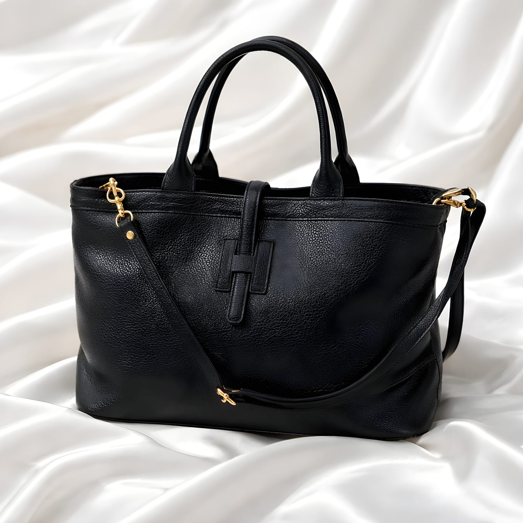 Czarna torebka damska skórzana z ozdobną tasiemką zabezpieczającą.