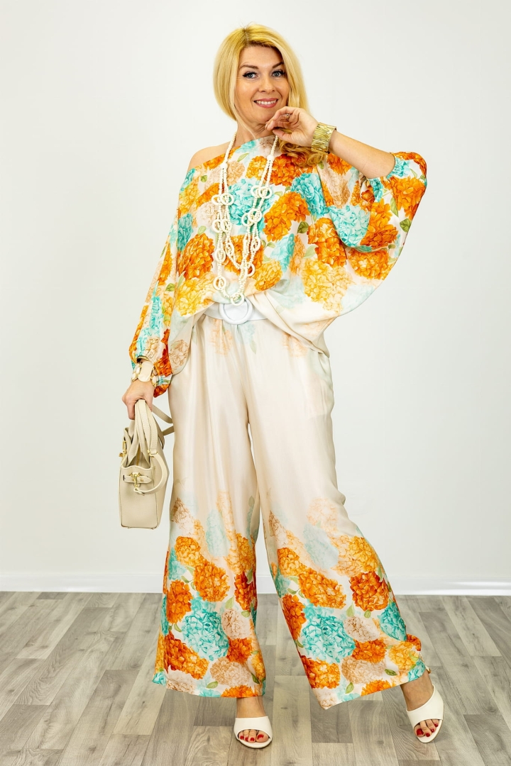 Spodnie satynowe La Scola z delikatnym połyskiem, długą nogawką i wiązanie w pasie oraz motywem kwiatowym na dole nogawki