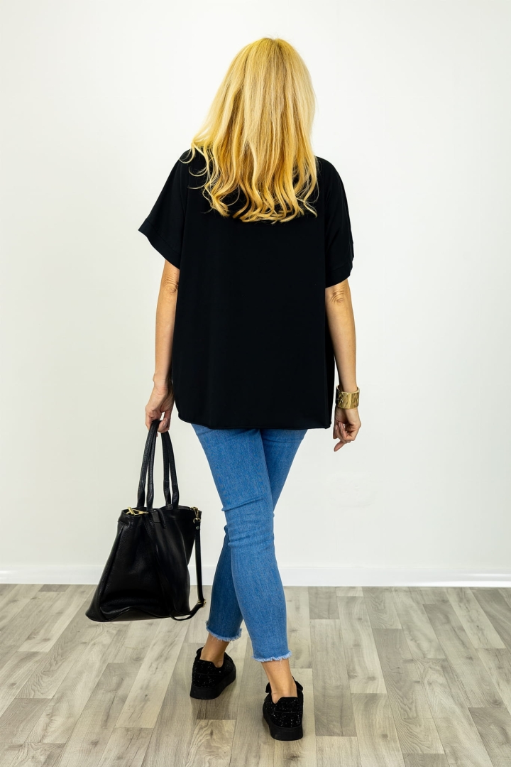 T-shirt Ingria w kolorze czarnym z ozdobnym kwiatem na piersi, w asymetrycznym fasonie.