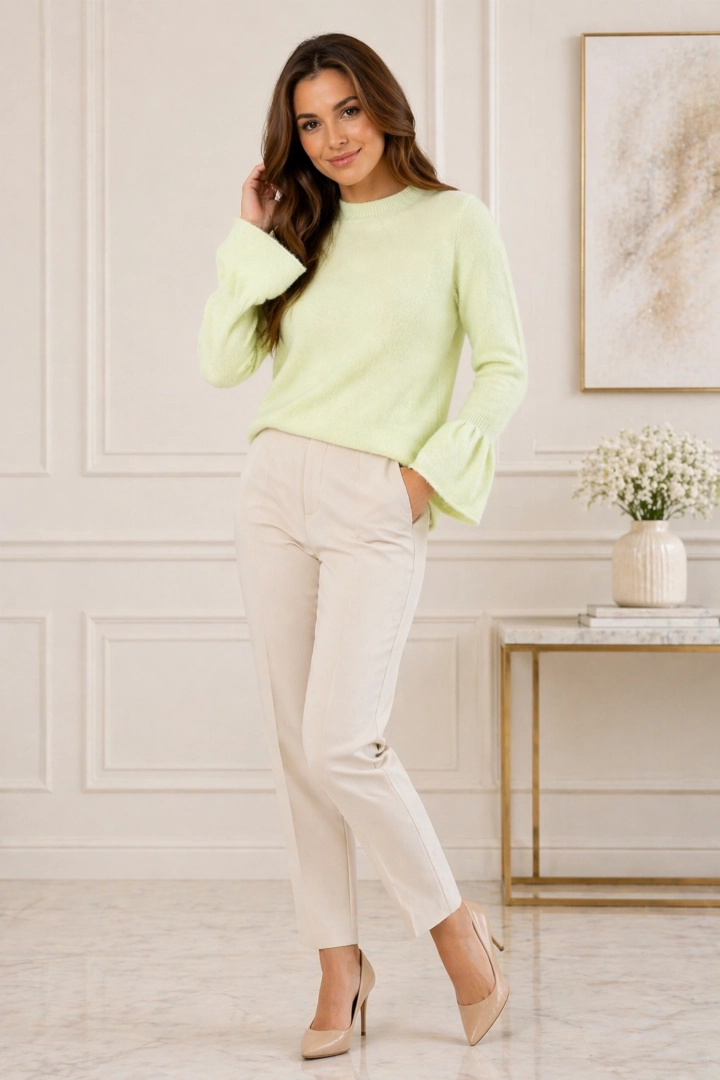 Sweter damski pistacjowy z okrągłym dekoltem i rękawami zakończonymi falbanką w codziennej stylizacji.