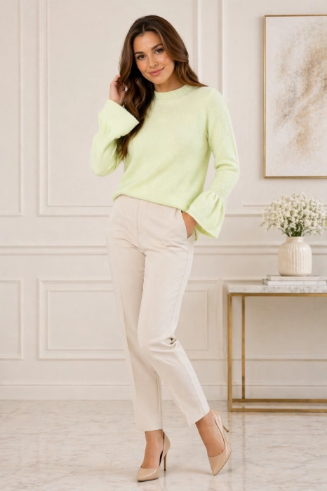 Sweter damski pistacjowy z okrągłym dekoltem i rękawami zakończonymi falbanką w codziennej stylizacji.