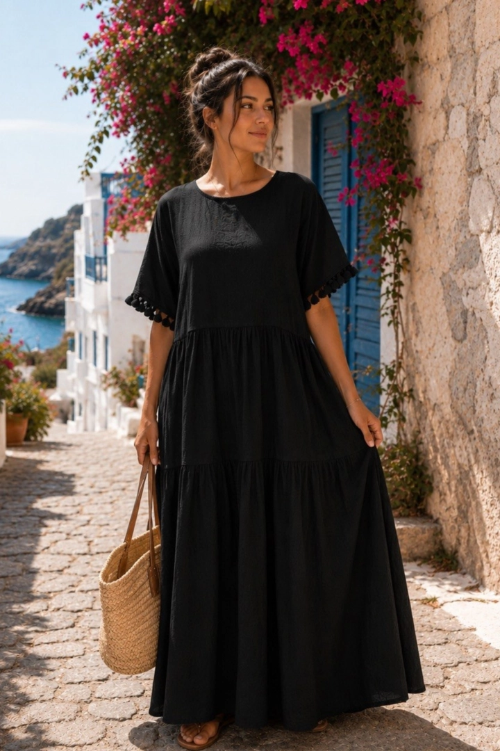 Czarna sukienka maxi boho z chwostami przy rękawach łączy ponadczasową elegancję z wakacyjną lekkością.